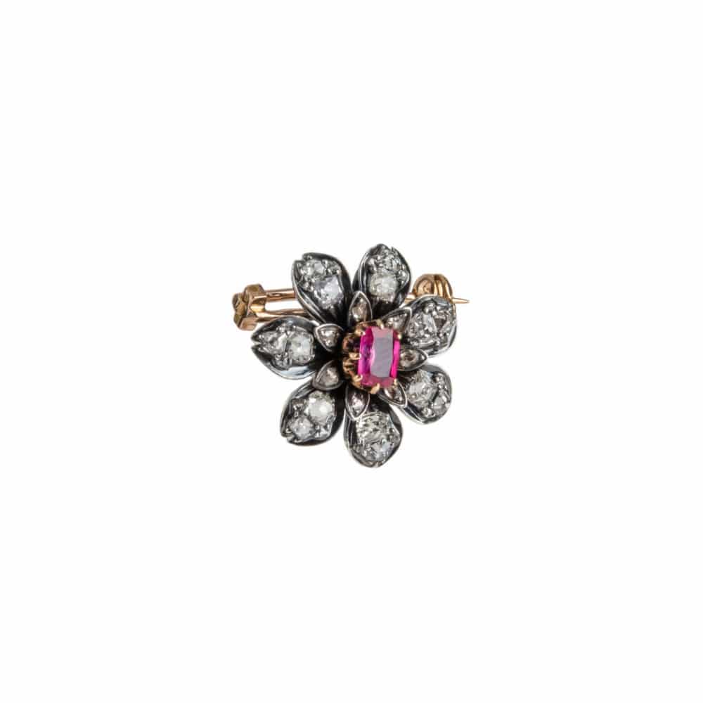 Broche vintage en or rose et argent noirci, motif floral serti d’un rubis entouré de 21 diamants